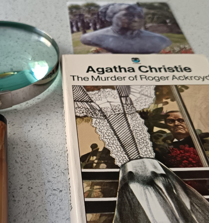 Foto einer Lupe und Bokk Cover von Agatha Christie's "Murder of Roger Ackroyd"